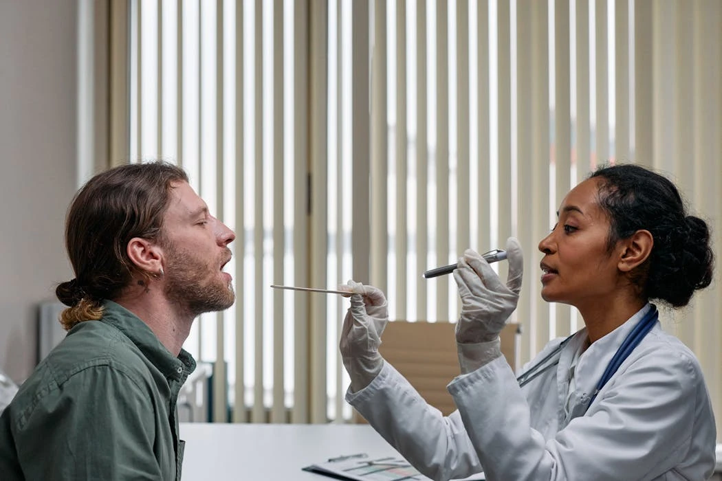 A doctor examining a patient's throat in a clinical setting, highlighting professional healthcare.